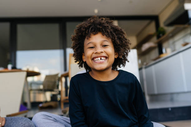 A young boy smiling with one front tooth missing.